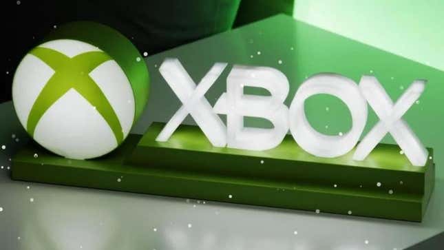 An Xbox sign lights up as snow falls.